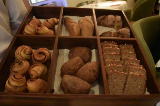 The very elegant bread basket featuring olive bread, corn bread, and other selections.