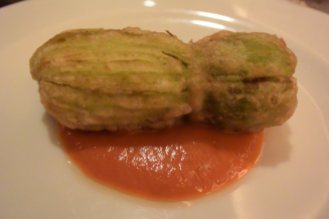 Zucchini flower stuffed with squid and burrata cheese, lightly fried and served over a paprika sauce. Amazing.